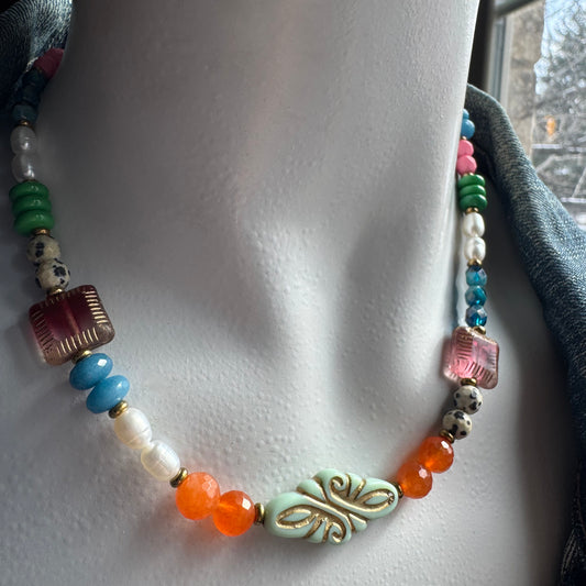 Colorful beaded necklace with decorative elements on a mannequin.