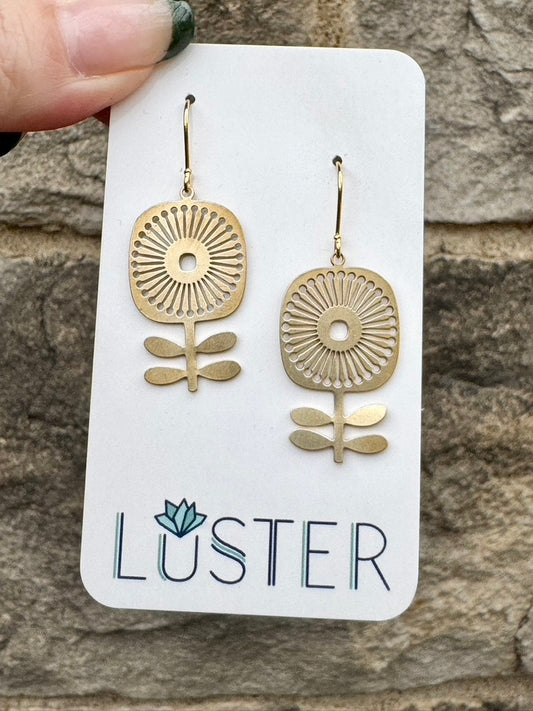 Gold mod flower earrings on a Luster branded card against a stone background
