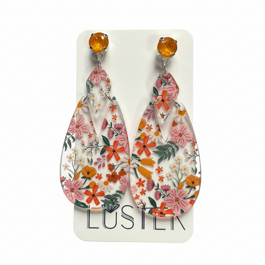 Floral earrings on a Luster brand card.