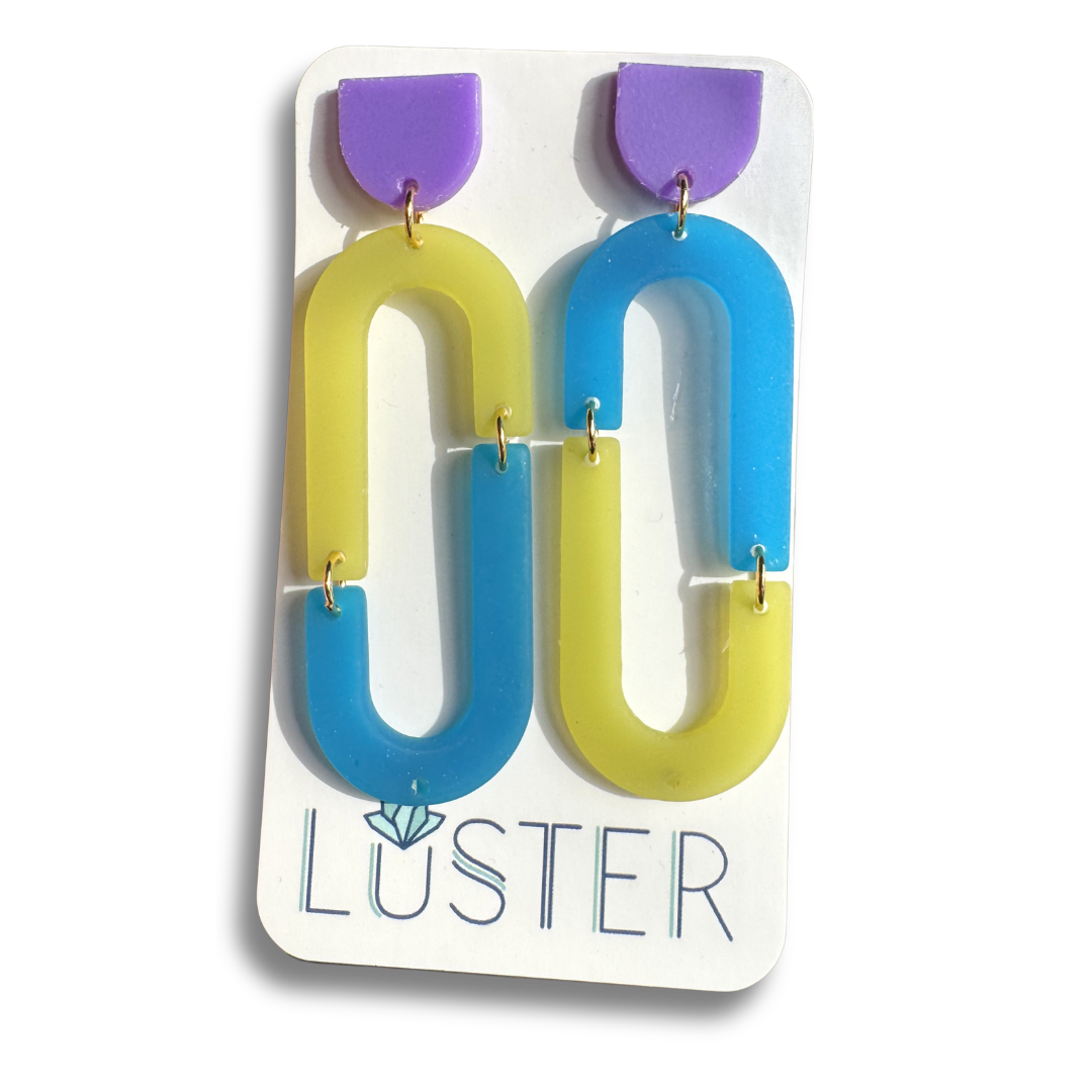 Colorful loop-shaped earrings on a Luster branded card.