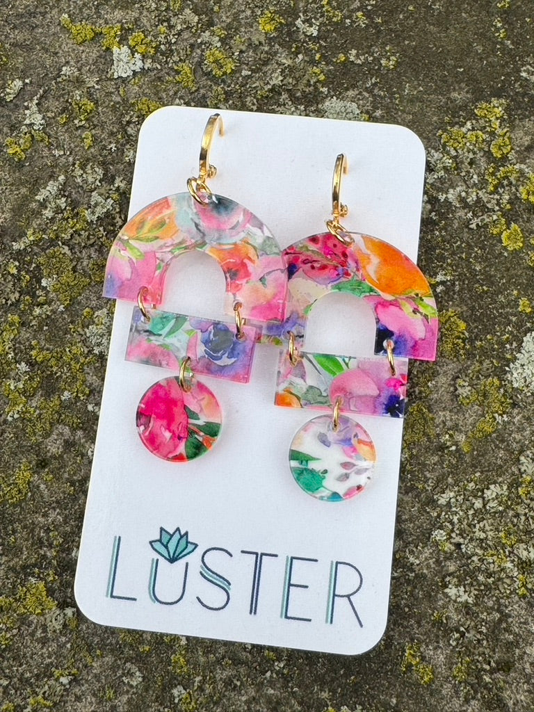 Colorful floral acrylic earrings set on a Luster branded white card.