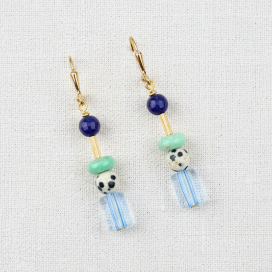 Earrings with colorful beads on a white linen background
