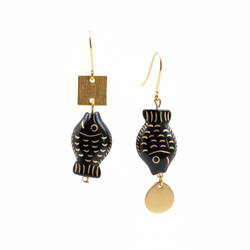 Black and gold fish-shaped earrings on a Luster branded card.