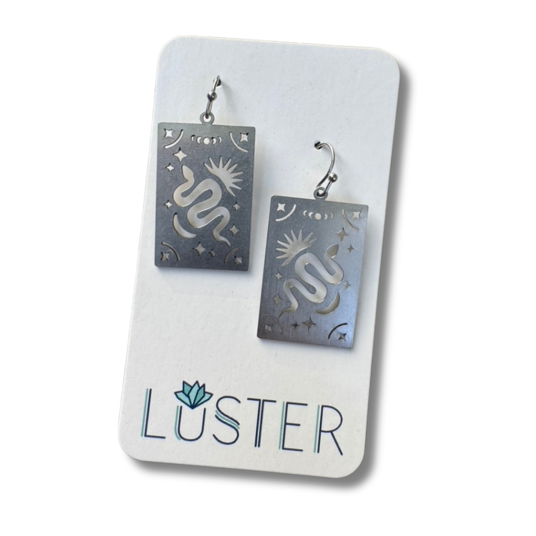 Earrings on a Luster branded card against a white background