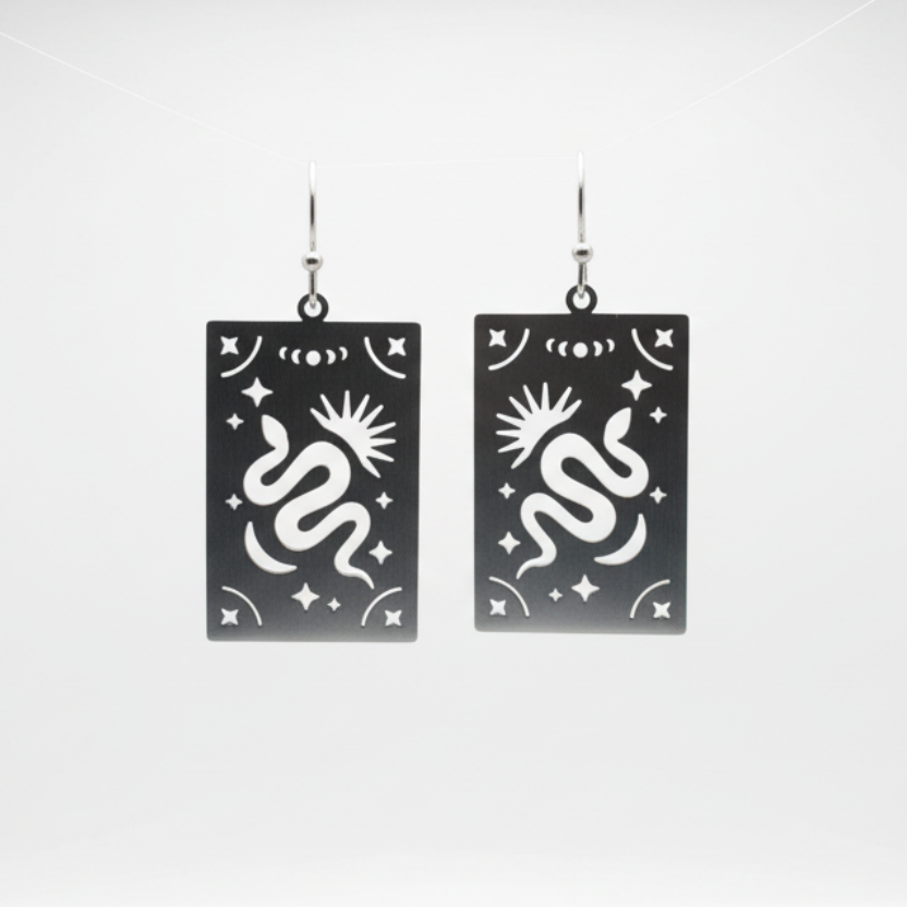 Steel snake earrings on a Luster branded card against a white background