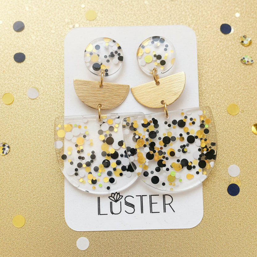 Pair of earrings on a Luster branded card with a gold background