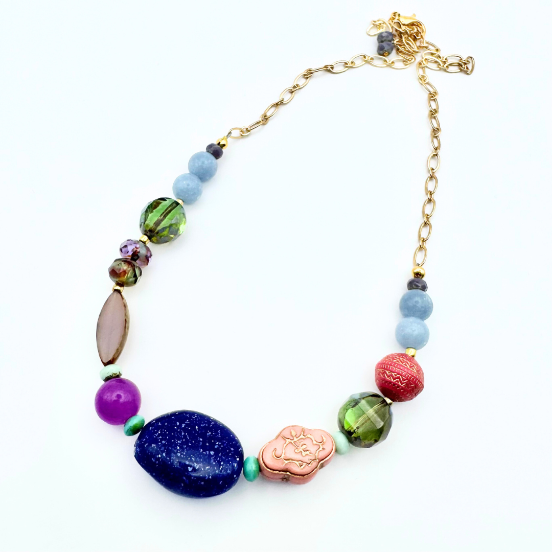 Colorful beaded necklace with gold chain on a white background