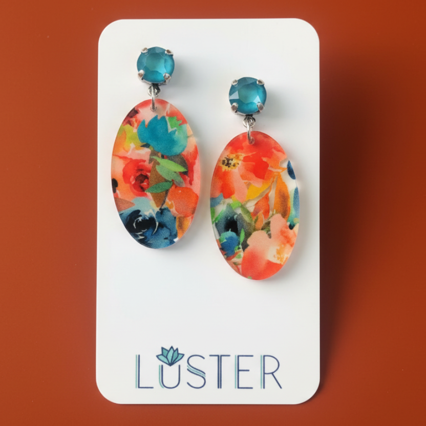 Acrylic oval floral earrings on branded card with orange background