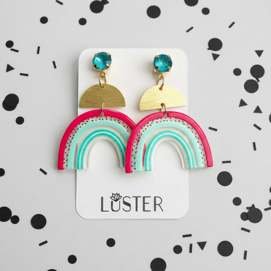 Fuchsia mint and teal rainbow earrings on branded card against black and white background