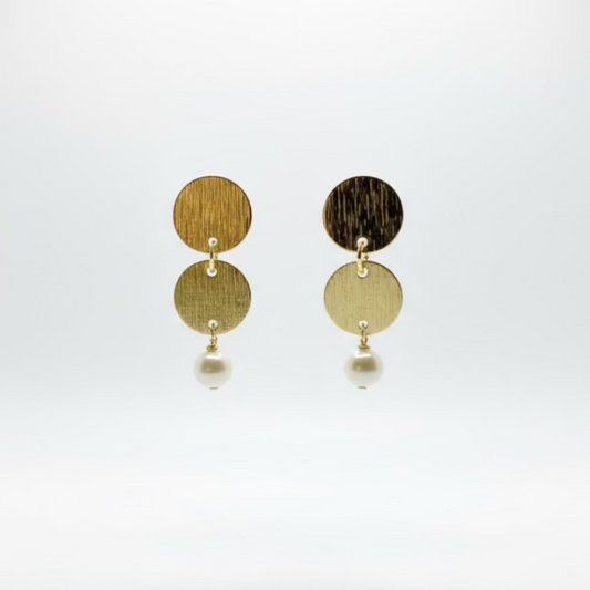Pair of brass circular earrings with pearls on a white background