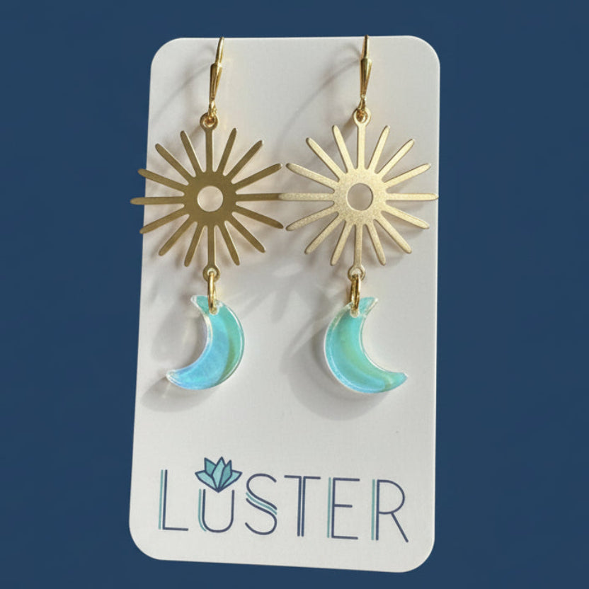 Sun and moon earrings on a Luster branded card against a blue background