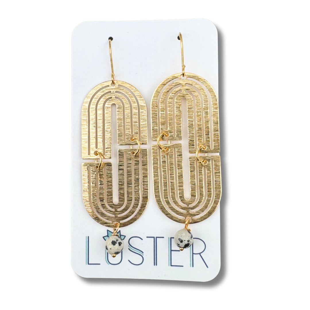 Gold arch-shaped earrings on a Luster branded card