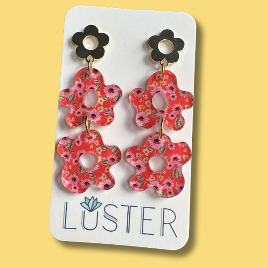 Floral earrings on a Luster branded card against a yellow background