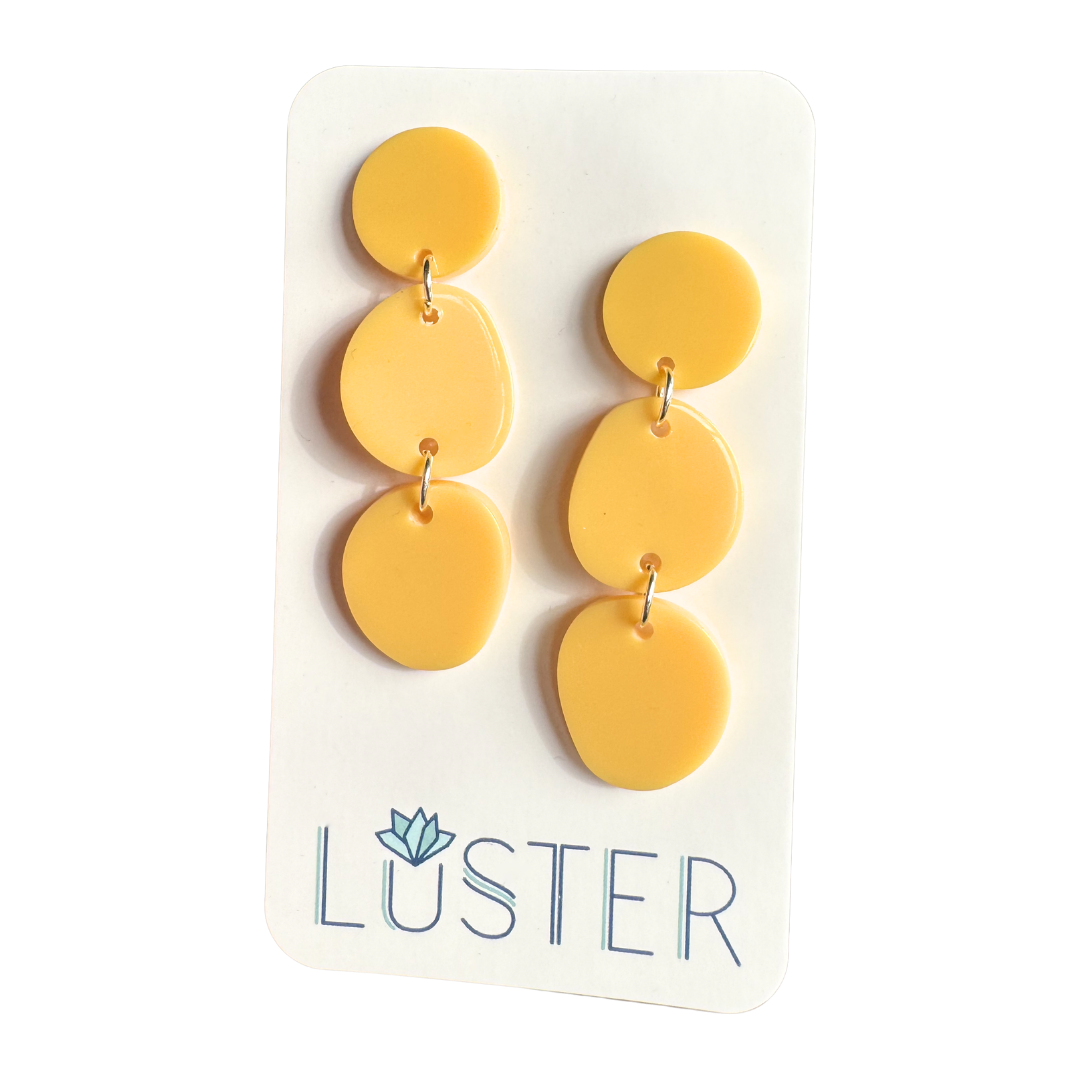 Yellow earrings on a Luster branded card