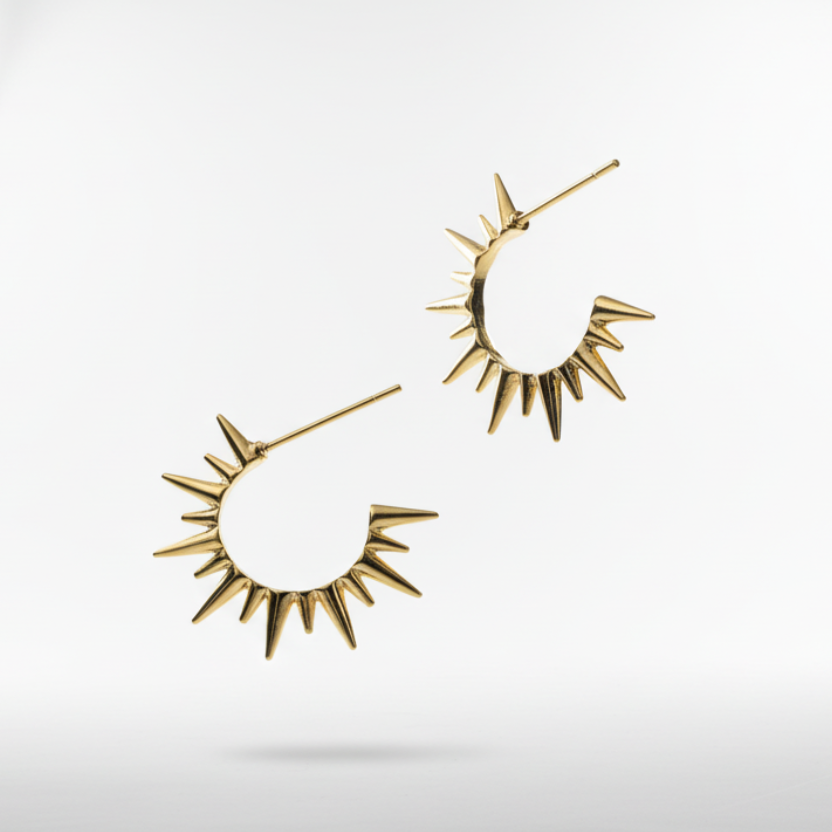Gold spike earrings on a light gray background