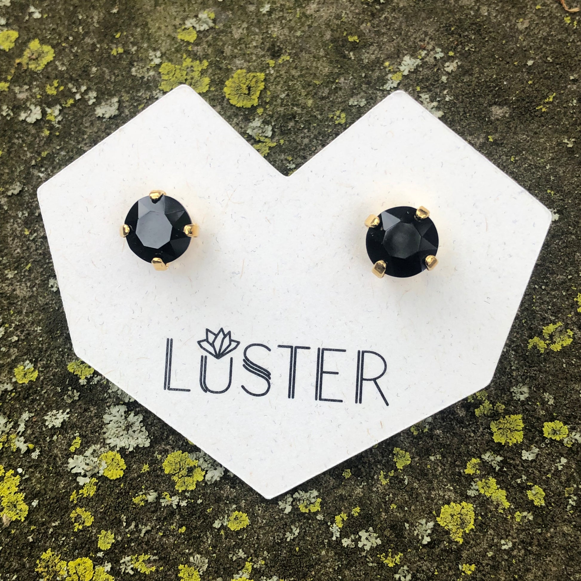 Black gemstone earrings on a Luster branded card with a natural background