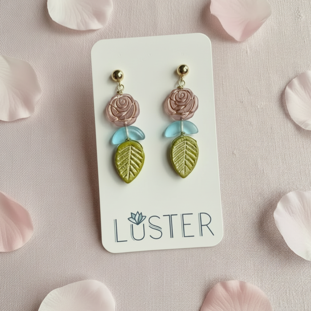 Pair of floral earrings on a Luster branded card with pink petals around