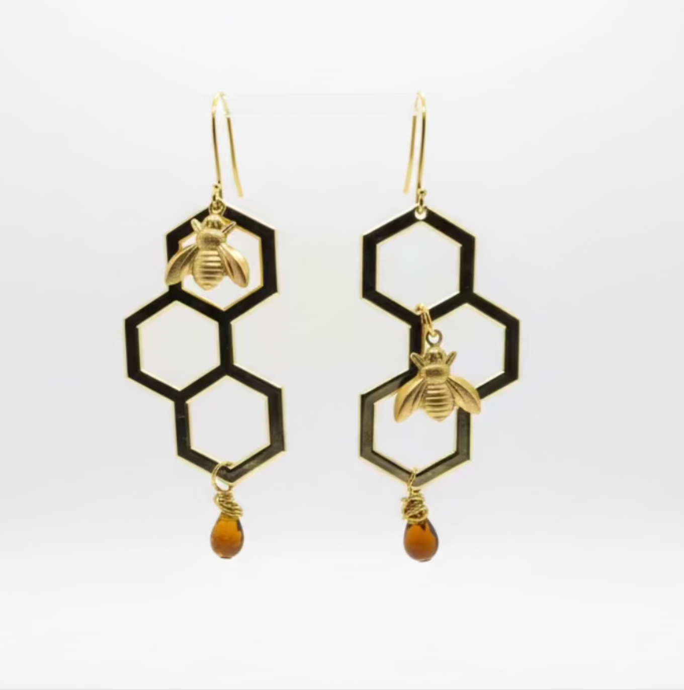 Hexagonal earrings with bee designs on a white background