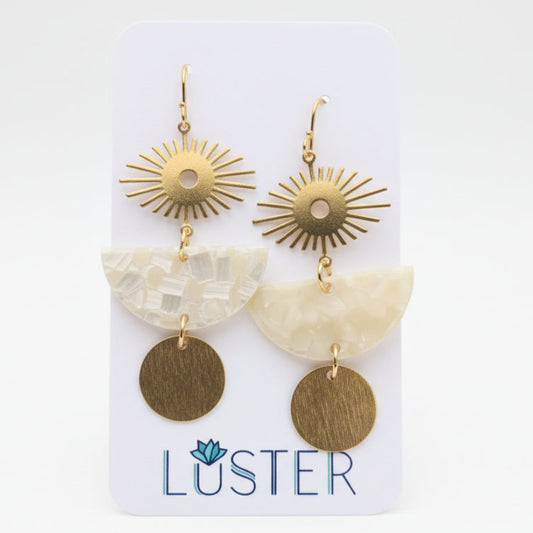 Pair of gold and beige earrings on a Luster branded card against a white background.