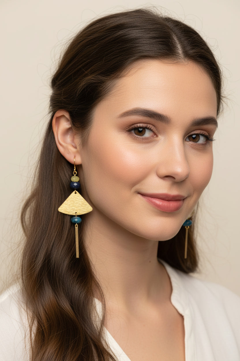 Pair of gold and blue beaded earrings on a female model.
