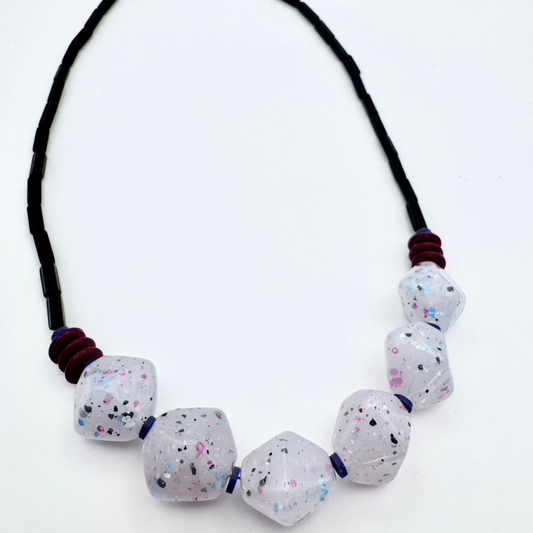 Necklace with speckled beads on a white background
