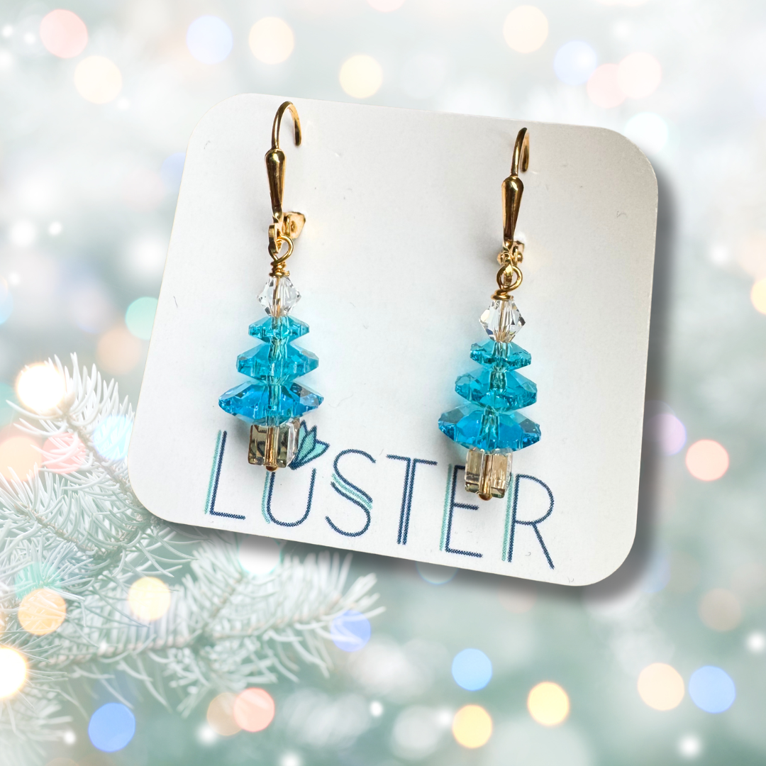 Blue beaded earrings on a Luster branded card with a festive background