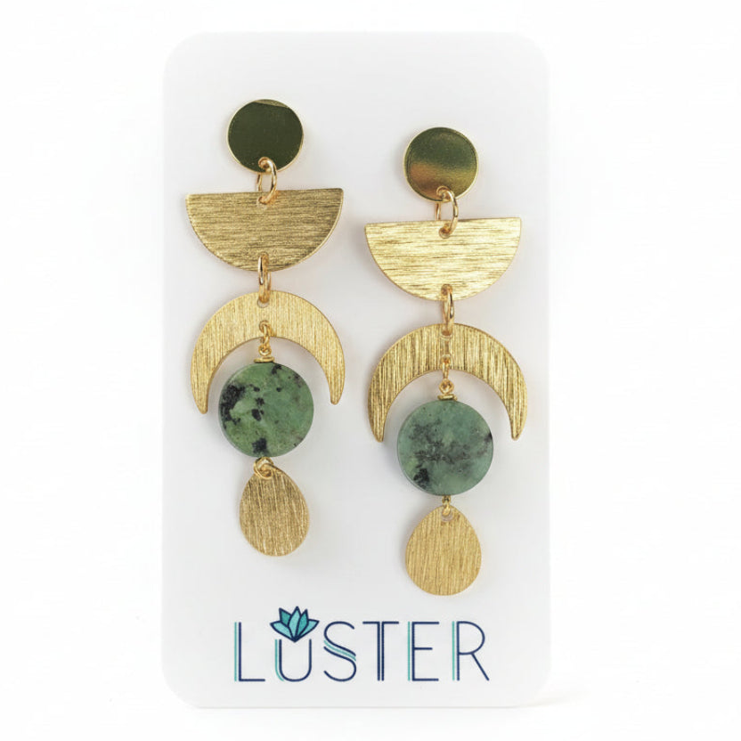 Brass celestial drop earrings on a branded earring card