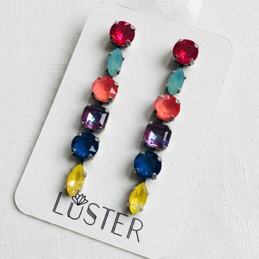 Colorful beaded earrings on a Luster branded card against a white background