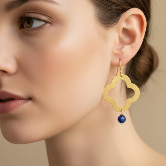 Gold earrings with blue beads on a female