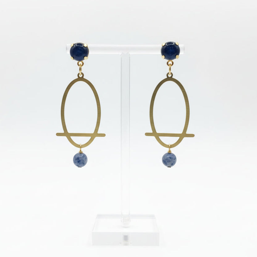Pair of gold earrings with blue stones on a white background